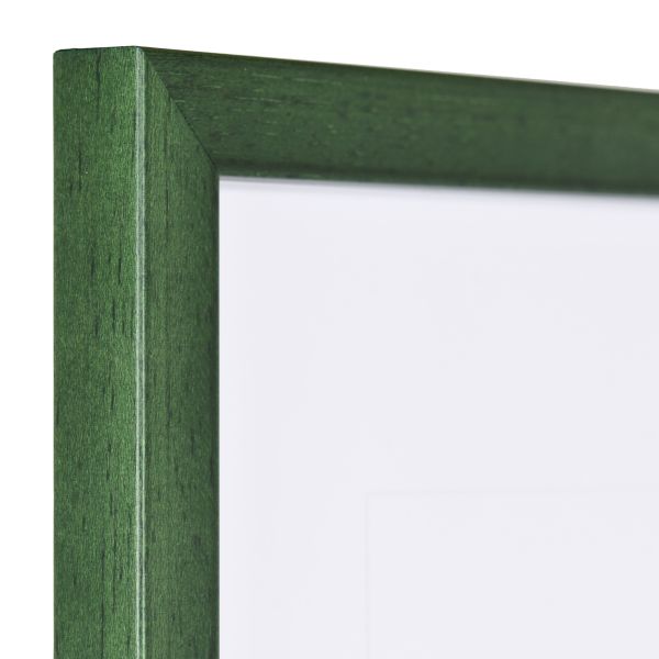 Vista de la esquina de un marco de fotos estrecho, verde abeto, con estructura de madera visible y superficie lisa